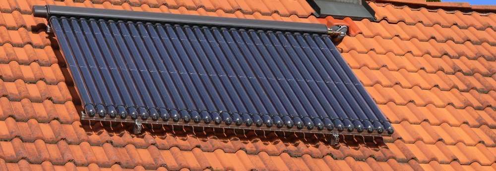 Eine Solarthermieanlage ist auf einem Ziegeldach montiert.